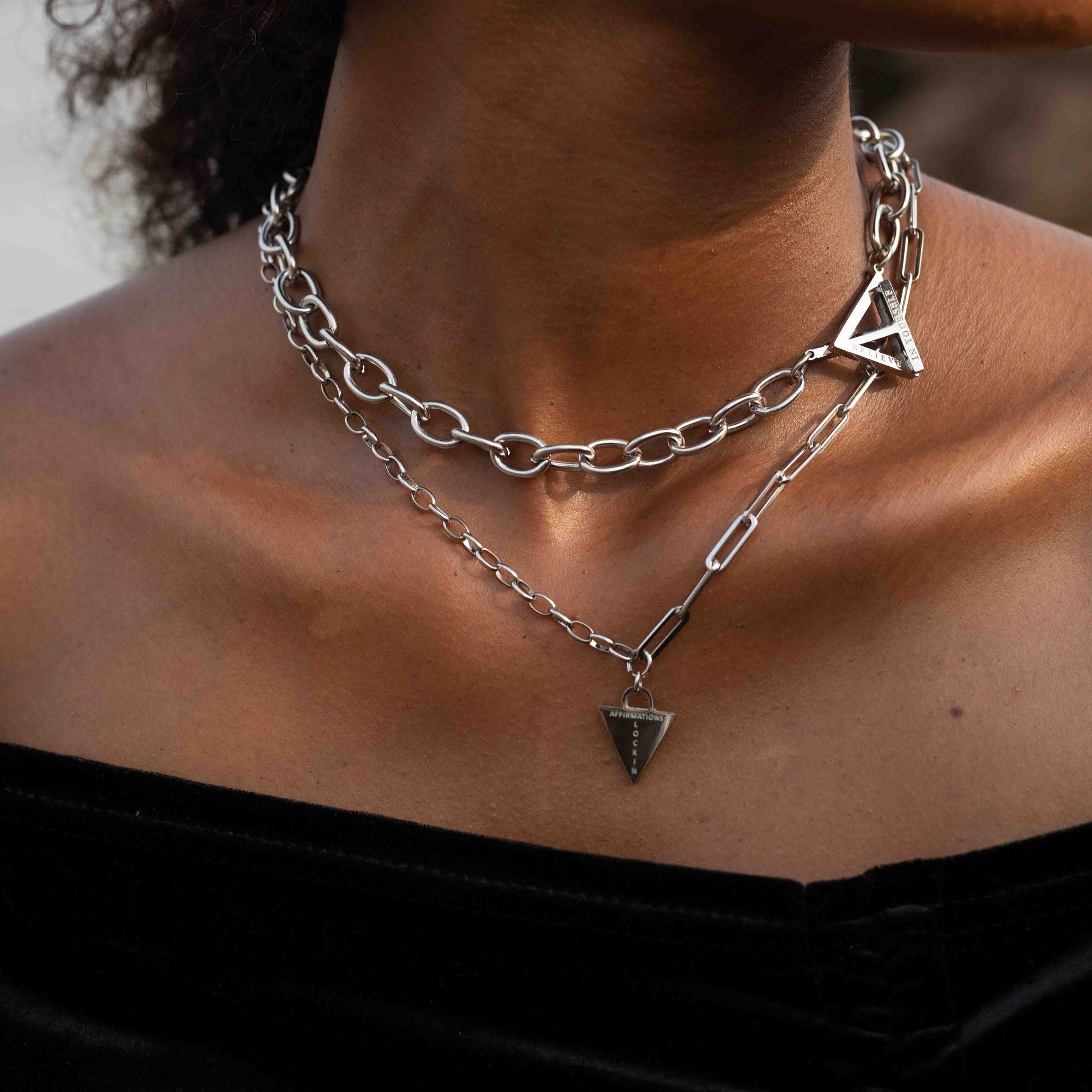 Female wearing chunky padlock silver necklace, engraved with affirmation lock in. Stacked with the believe in yourself chunky necklace 