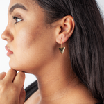 Woman showing off gold triangular empowering earrings