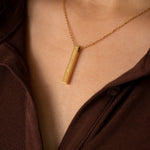 Woman wearing gold empowering necklace